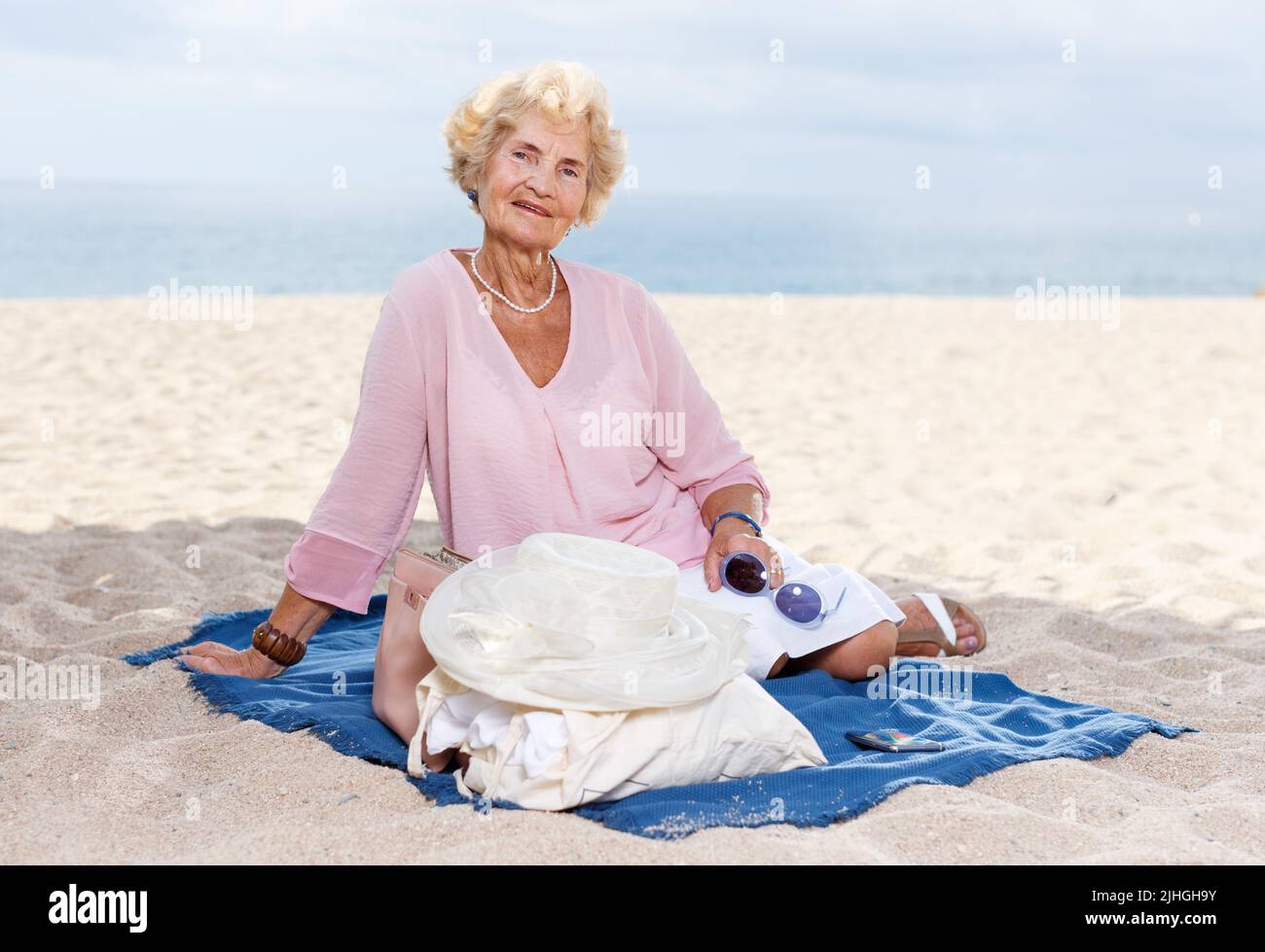 Elderly woman relaxing on beach Stock Photo - Alamy