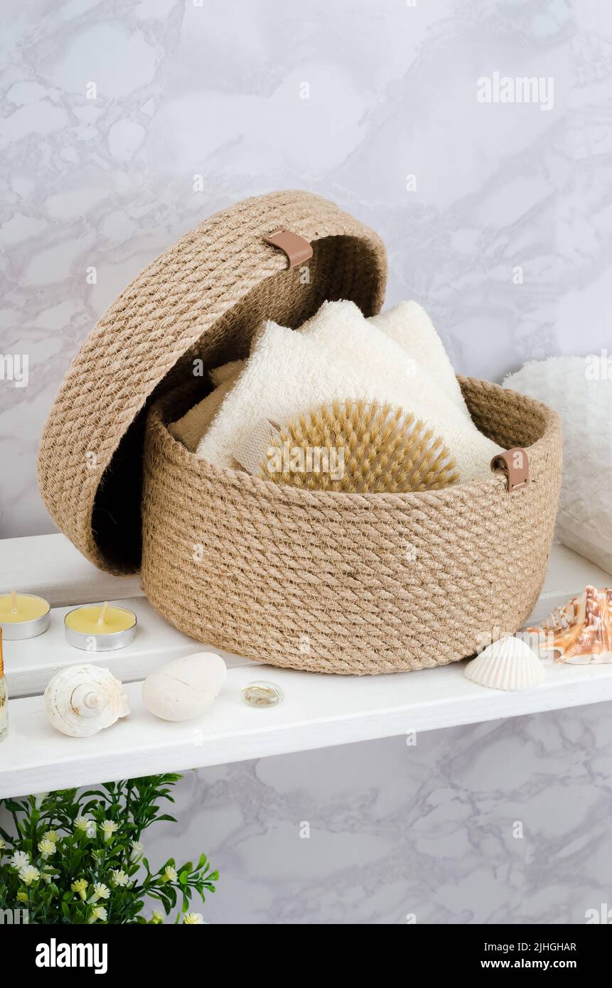 Hand knitted jute basket with a lid with towels and a brush in the