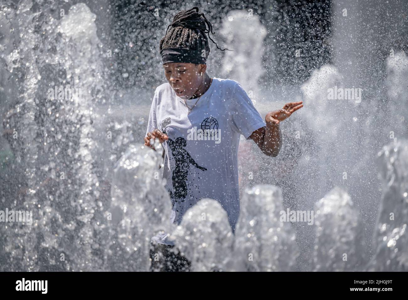 London, UK. 18th July, 2022. UK Weather: Heatwave Monday. Locals cool off in the Wembley Park water fountains as temperatures continue to rise with an amber alert in place for extreme heat. Britain could soon experience its hottest day as Met Office predicts Britain could hit 41C high. Credit: Guy Corbishley/Alamy Live News Stock Photo