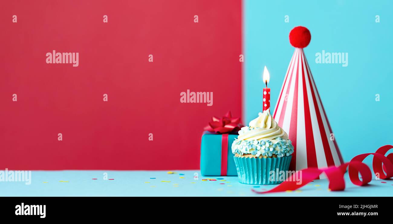 Birthday party background with birthday cupcake, birthday gift and birthday party hat Stock Photo