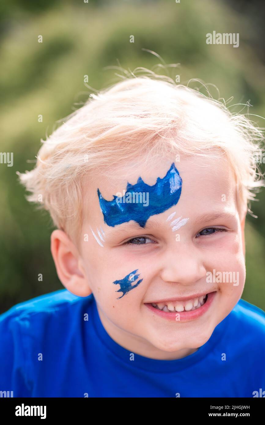 Cute little boy with face paint with batman pattern. Face painting, kid