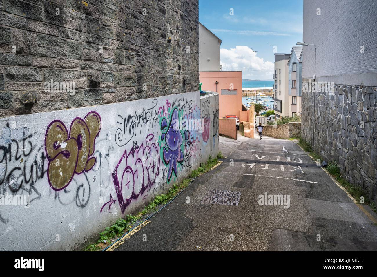 Ugly damaging graffiti and tags sprayed on a wall in a side street in Penzance Towan centre in Cornwall in the UK. Stock Photo