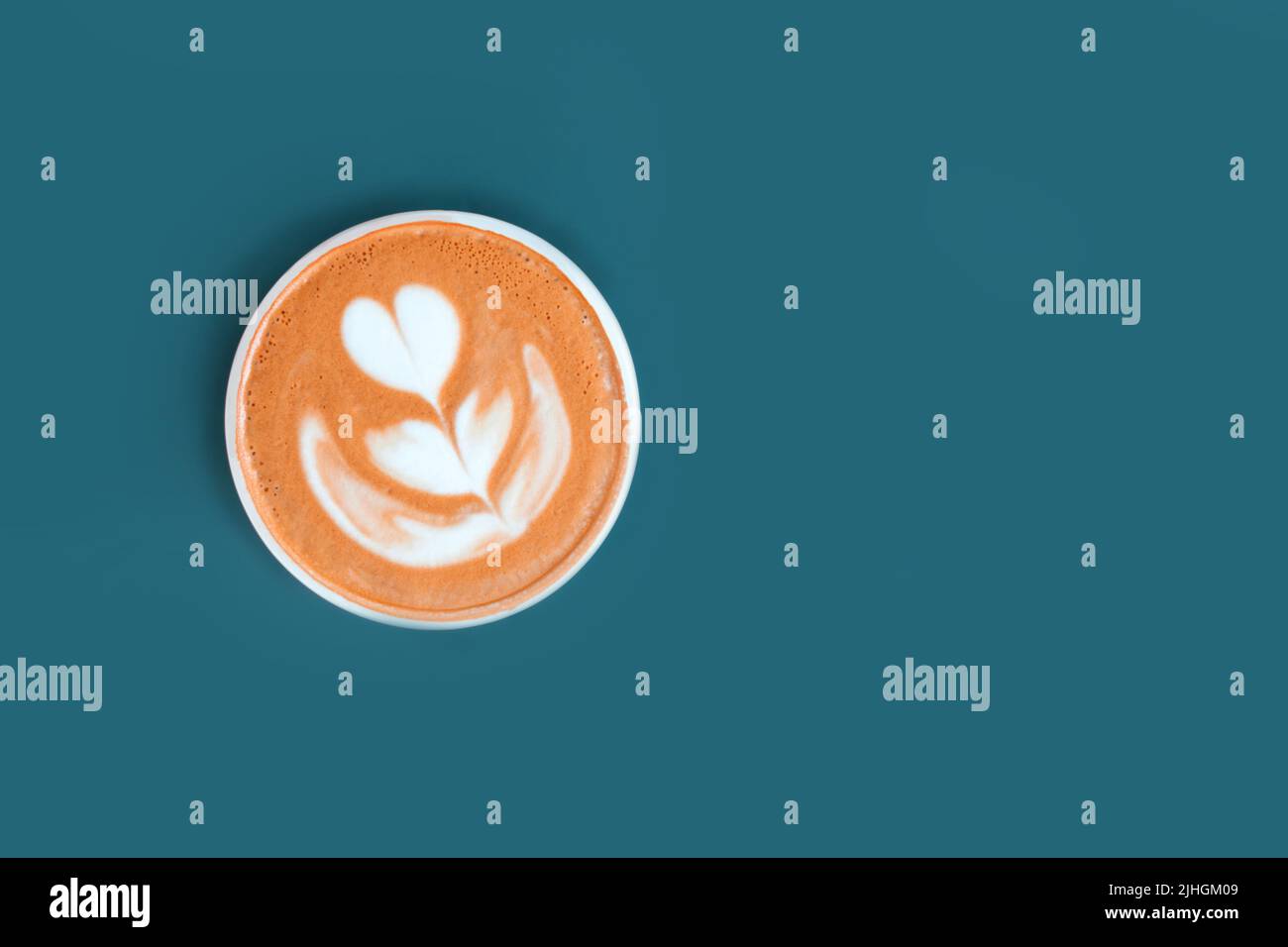 Cappuccino with frothy foam, coffee cup top view is on the blue