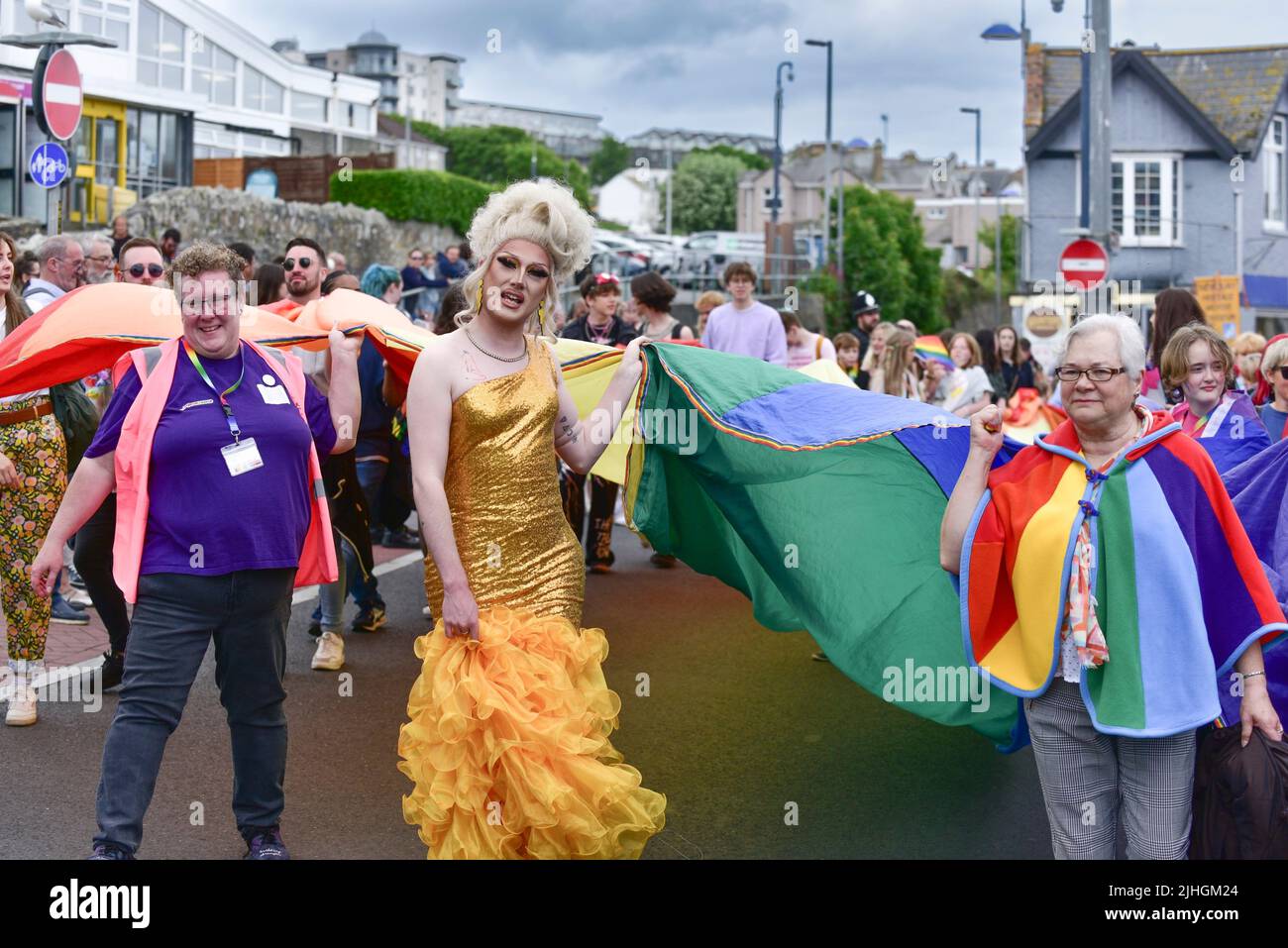 A flamboyant Drag Queen leading the vibrant colourful Cornwall Prides Pride parade in Newquay Town centre in the UK. Stock Photo