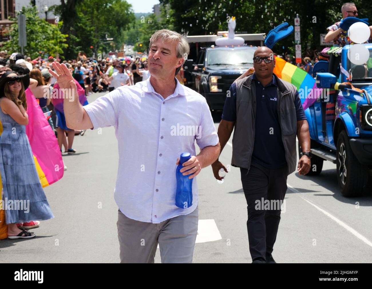 The Halifax Pride Parade through streets of city. NS Premier Tim Houston waves at crowd. Stock Photo