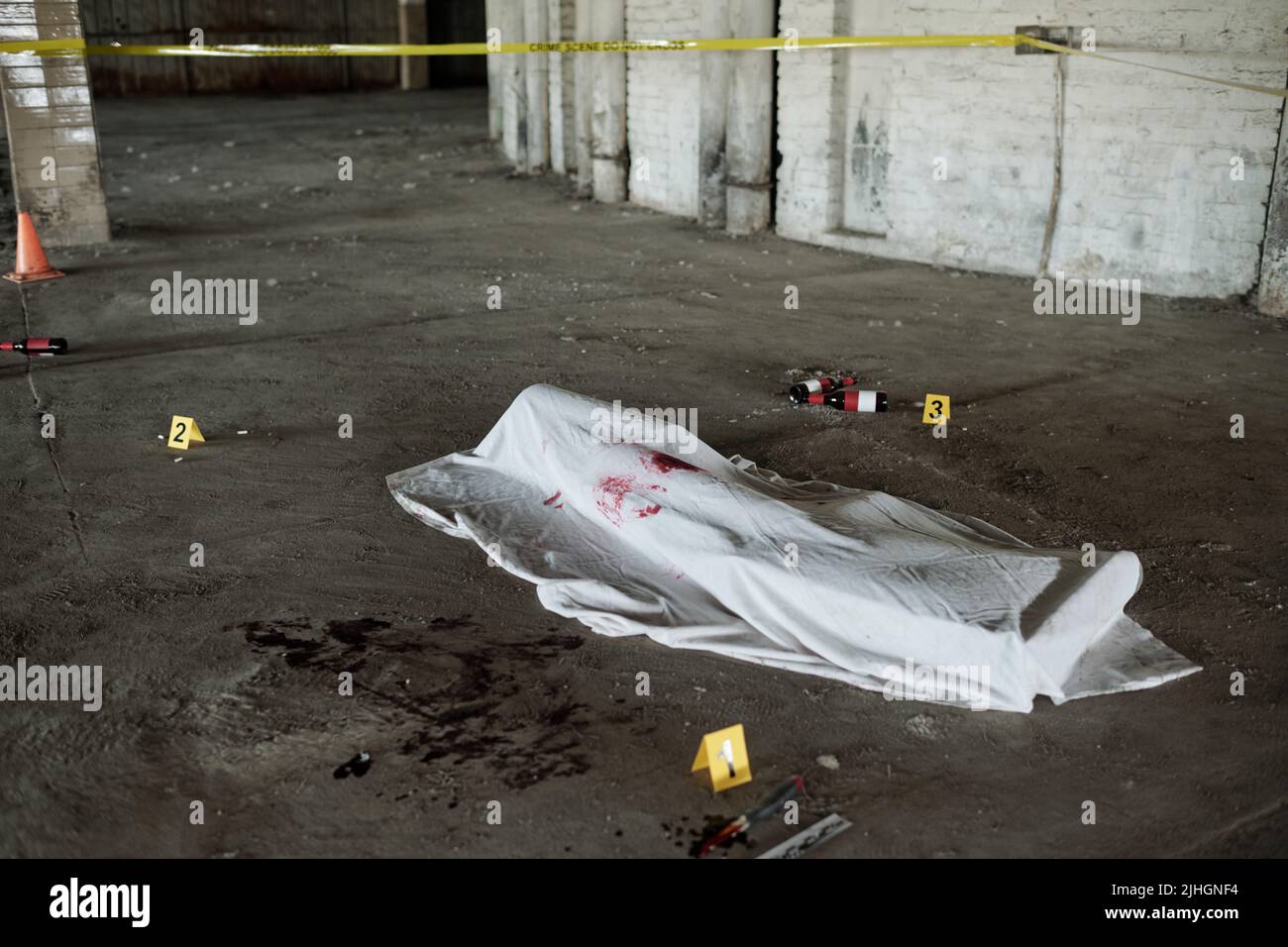 White sheet with fresh stains of victim blood covering dead body shot