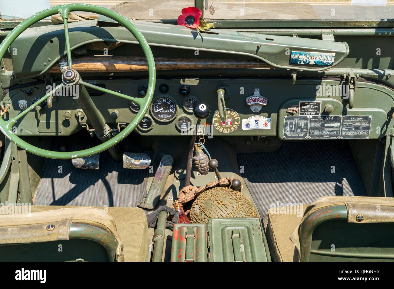 The dashboard of a classic world war two American army jeep. Steeling wheel and gauges, with a grenade hanging from the main dashboard. Stock Photo