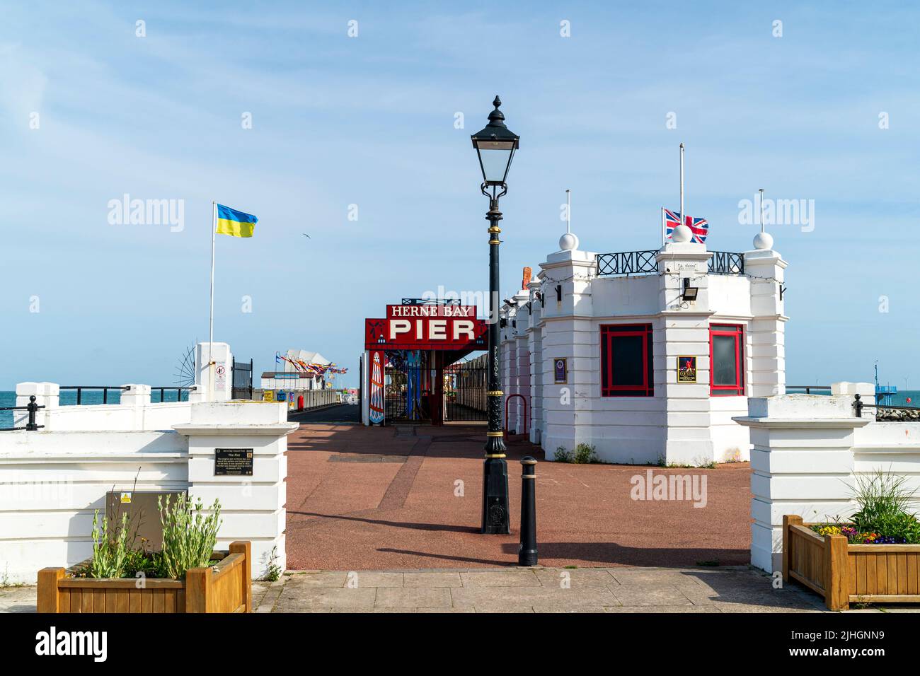 The small white office building at the entrance to the pier at the Kent resort town of Herne Bay in the early morning on a summer's day. Blue sky. Stock Photo