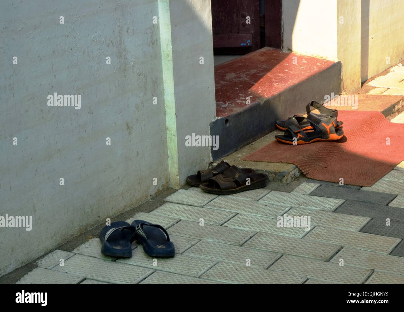 sandals on pavement outside front door, kerala, india Stock Photo