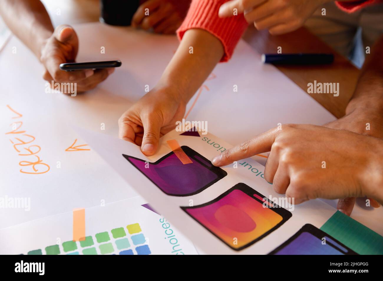 Creative multiracial design professionals discussing over charts in office Stock Photo