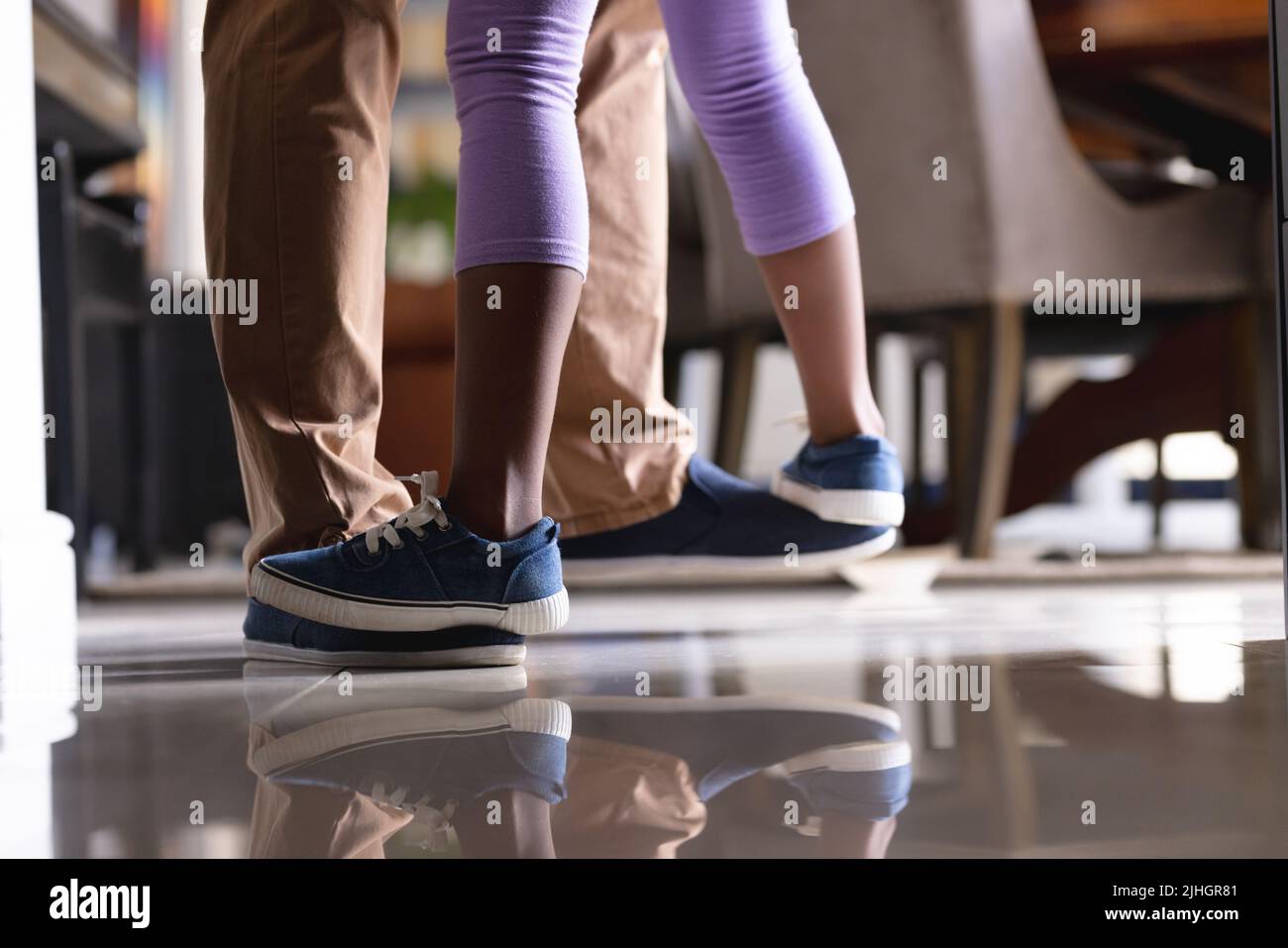 Image of legs of african american father and daughter dancing in kitchen Stock Photo