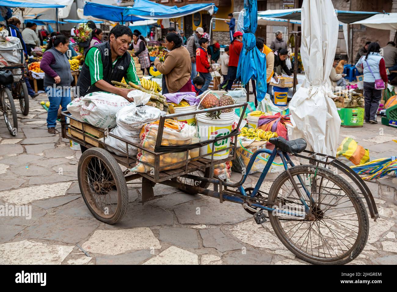 Man with produce on tricycle, Pisac Sunday Market, Cusco, Peru Stock Photo