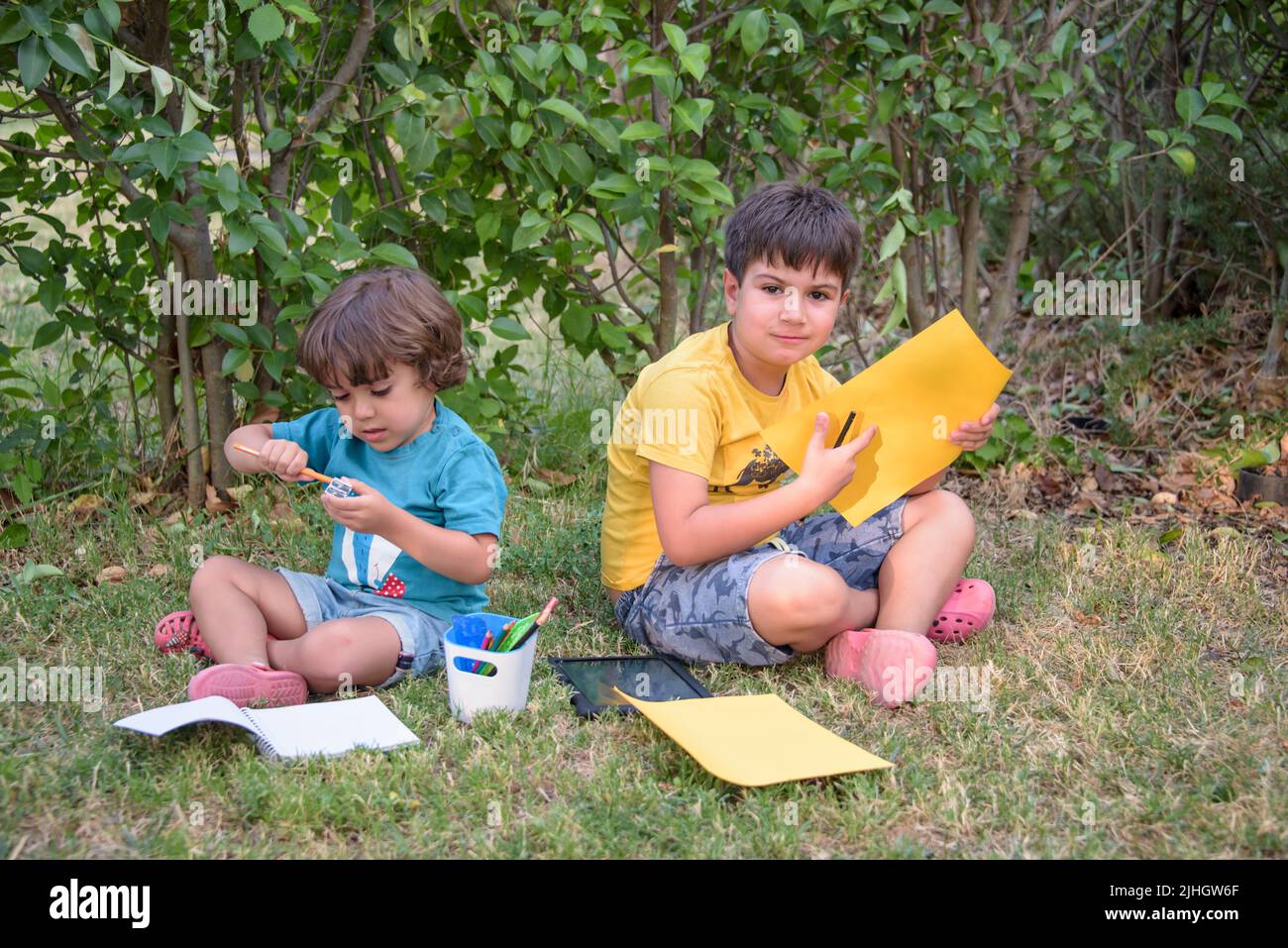 Back to school. Two happy and cheerful children, a schoolboy with notebooks and paints in their hands in the park. Stock Photo