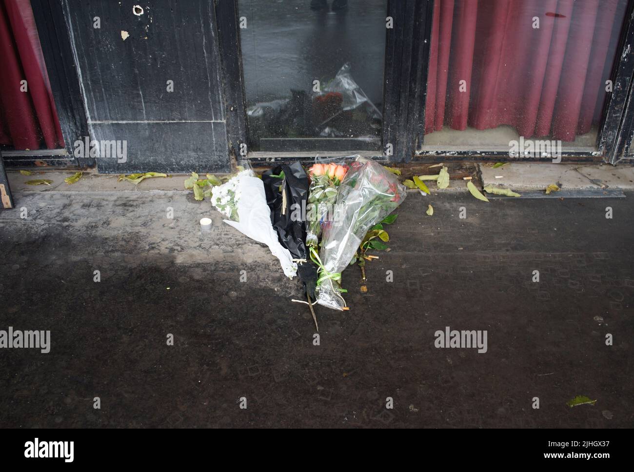 Flowers lie on pavement in front of Bataclan music venue commemorating victims of the tragic November 2015 Paris attacks. Le Bataclan, 50 Boulevard Voltaire, Paris, France - Paris terror attacks - a year on Stock Photo