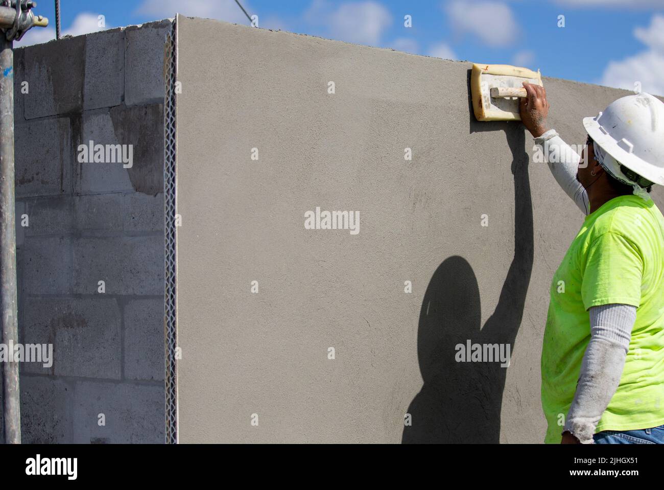 A construction worker is using a sponge trowel to smooth out the final