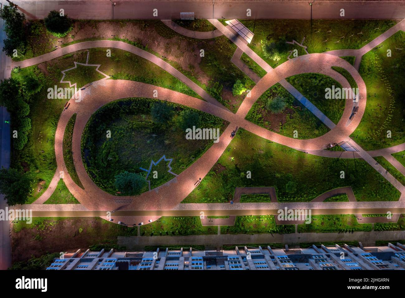 Night paved path road in the shape of a figure eight in the city courtyard at night. Top aerial view Stock Photo