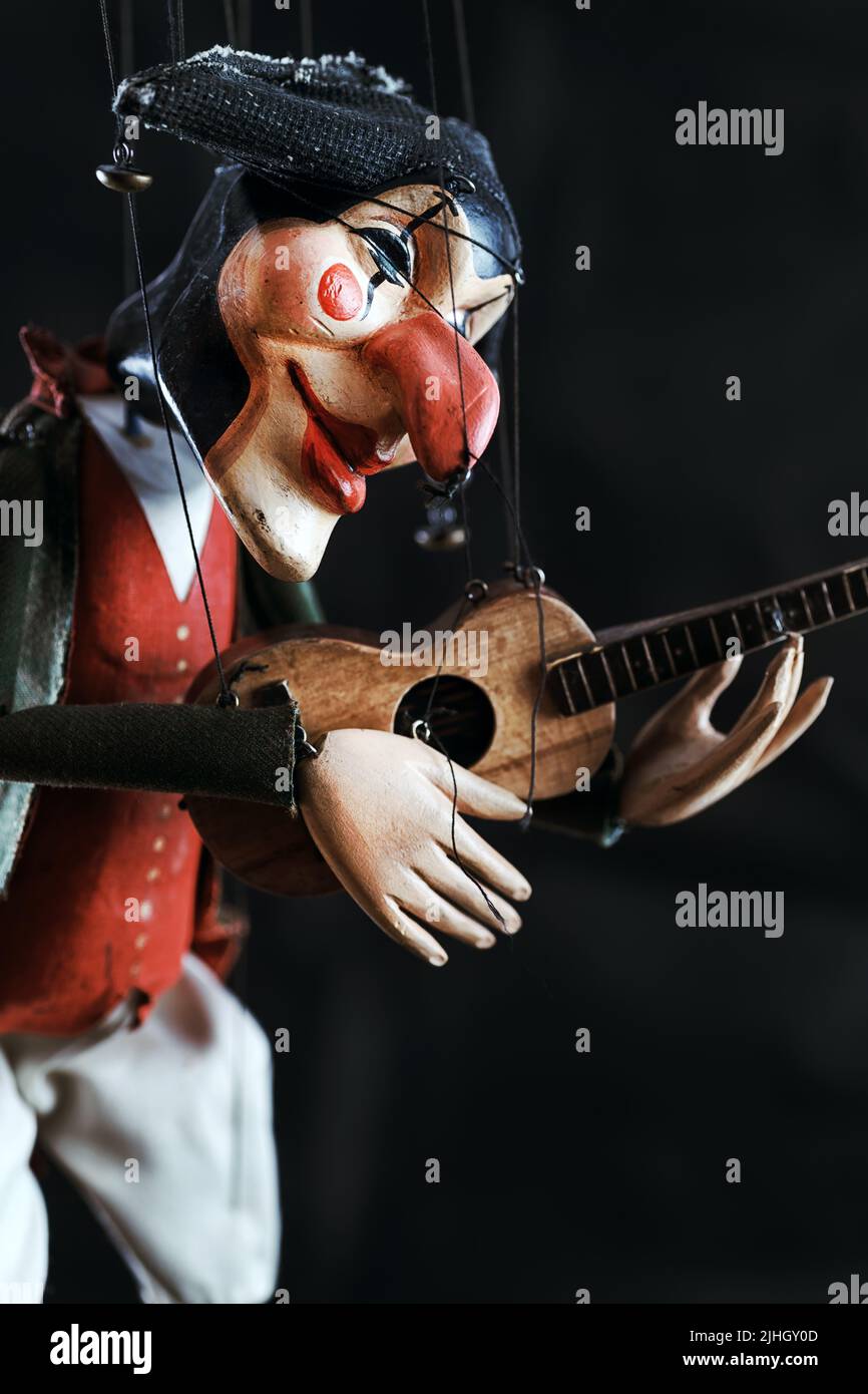 Handmade harlequin puppet. Puppet doll in the style of del arte on strings with selective focus Stock Photo
