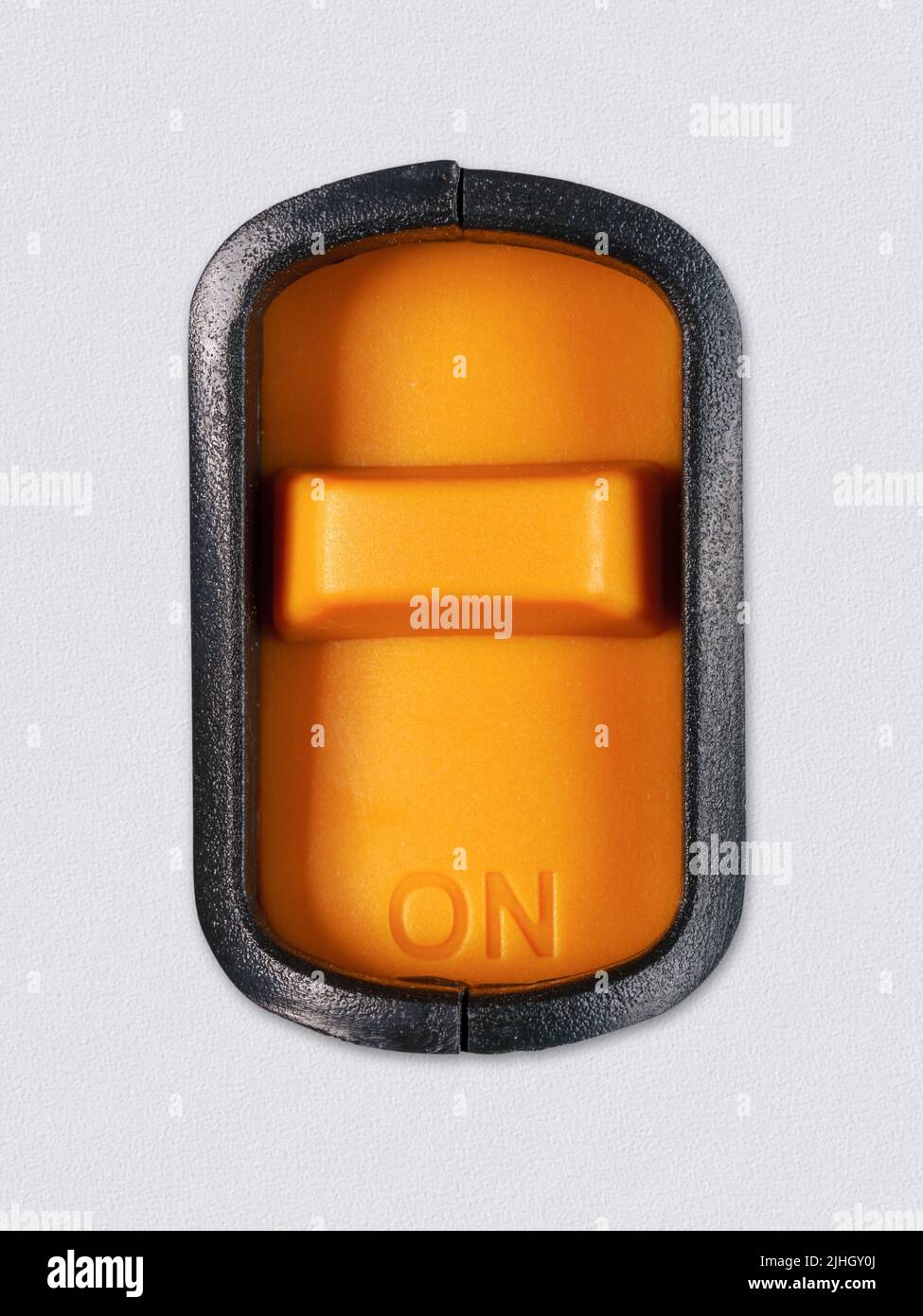 Bright orange switch with an inscription 'On' on it. Clipping path on the swith. On white plastic background Stock Photo