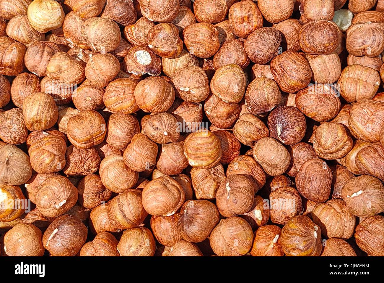The lots of hazelnuts without shell as food background. Closeup Stock