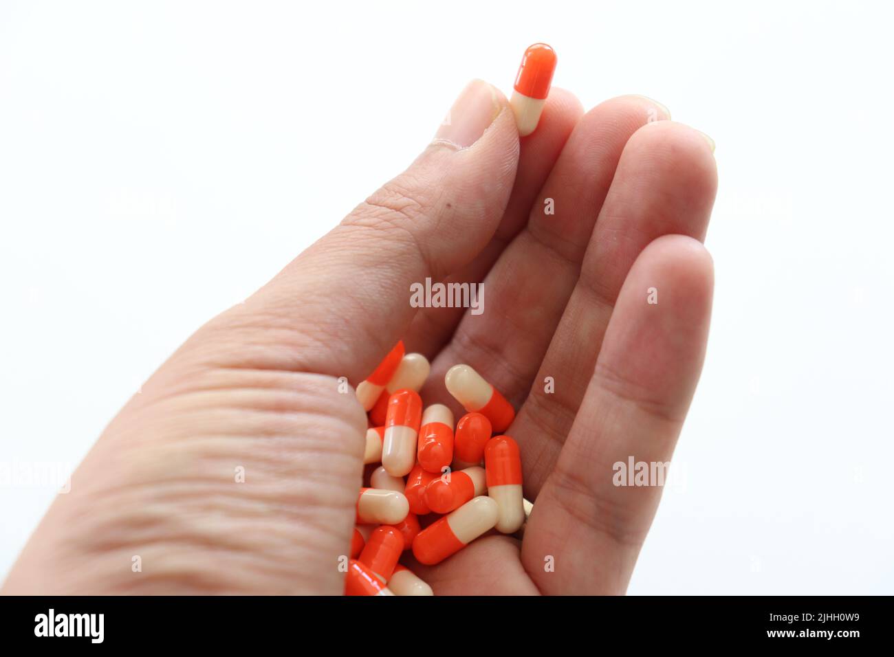 Medicine in hand. Patient committing suicide by overdosing on medication. Close up of overdose pills. Sad unhappy man holding medicine in palm. Stock Photo