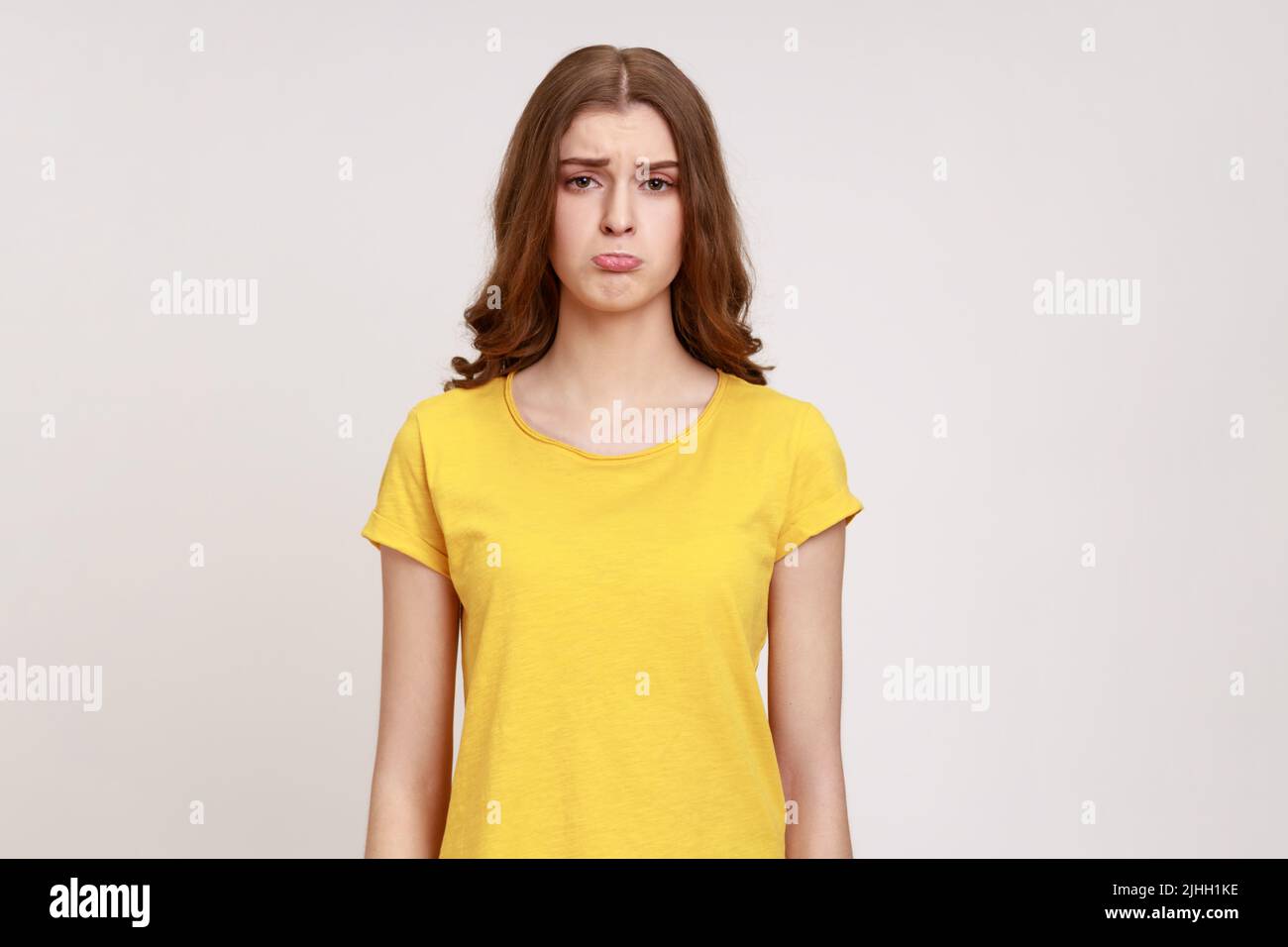 Portrait of sad beautiful teenager girl wearing yellow T-shirt looking ...