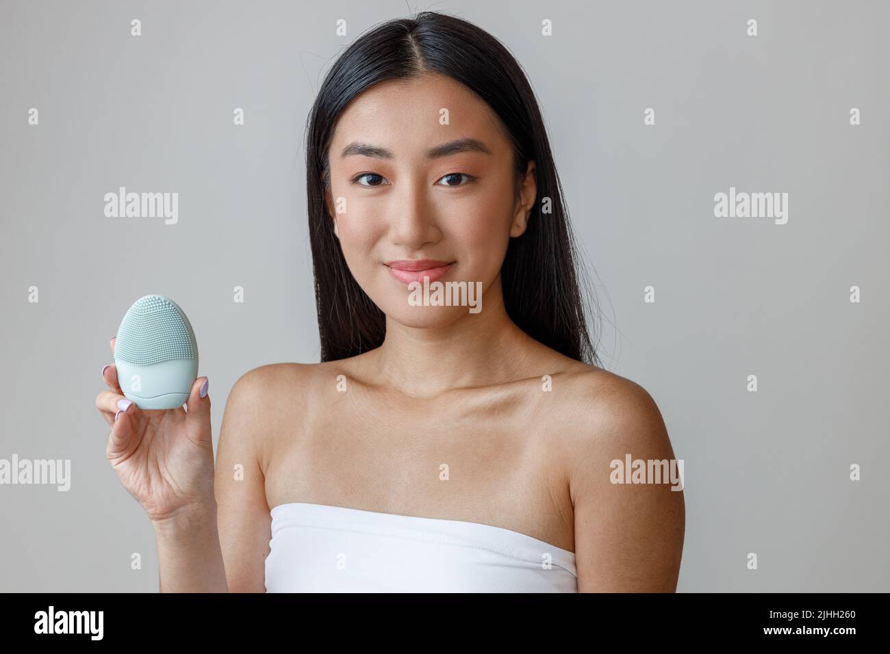 Asian young woman holding cleansing face massager Stock Photo