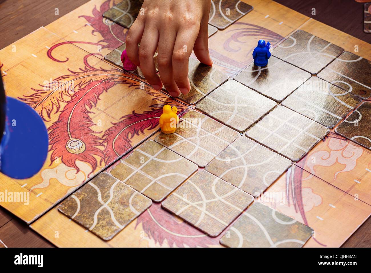Closeup hand playing board game similar to as Tsuro. table game or