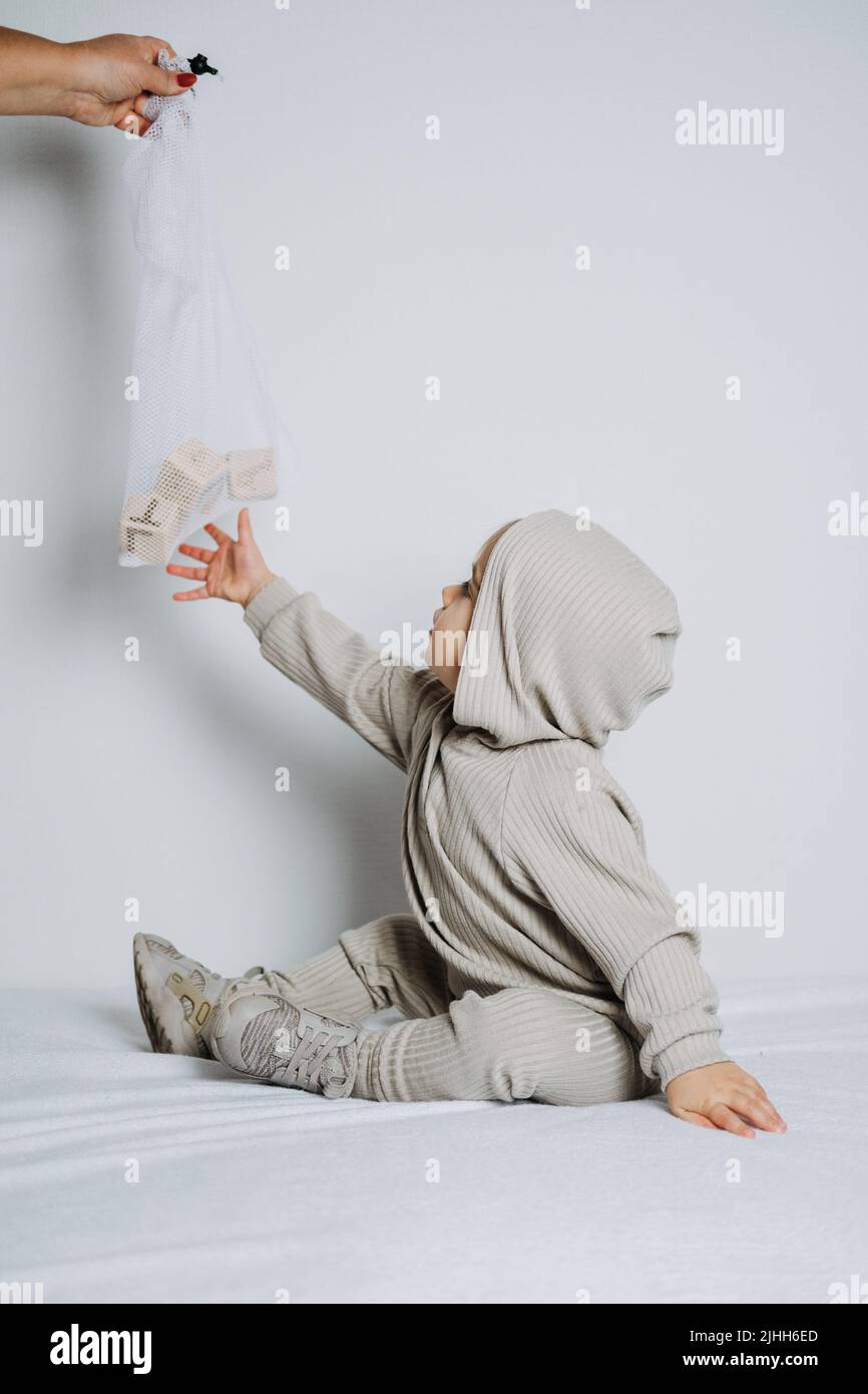 Baby fashion. Unisex clothes for babies. Cute baby in cotton set suit on light background. Stock Photo