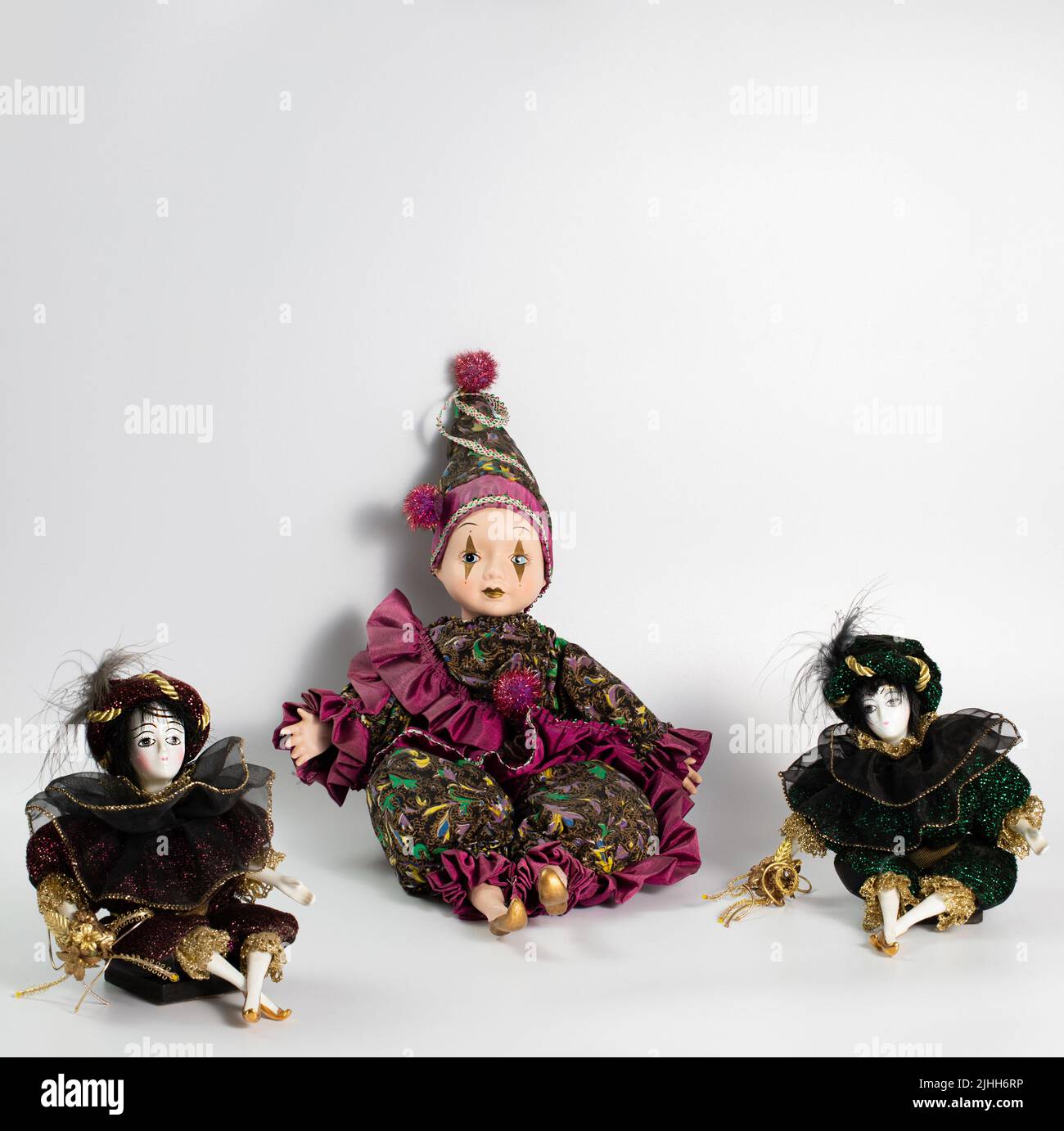 Porcelain realistic vintage toys, harlequin. The dolls are dressed in a carnival outfit, decorated with gold, vintage concept, decoration Stock Photo