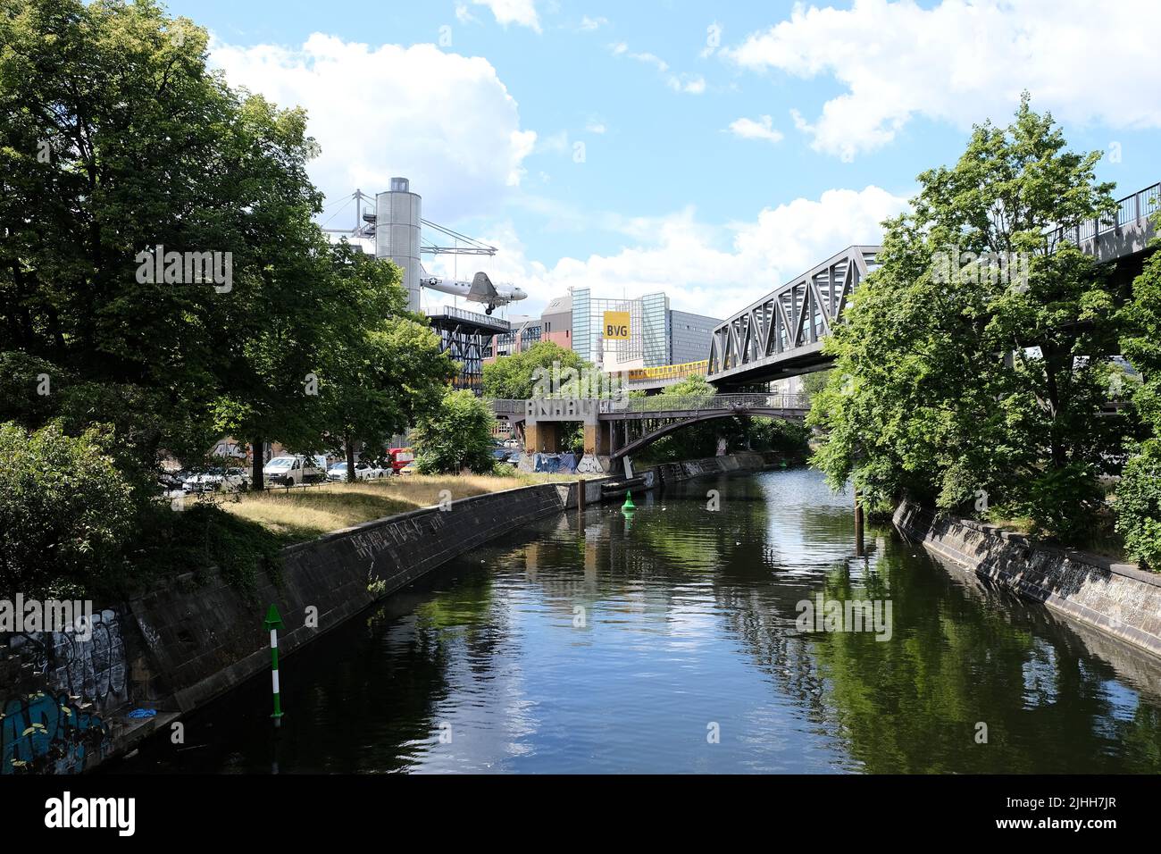 Berlin, Germany, July 11, 2022, view over the Landwehrkanal with iron girder bridge of the elevated railroad, BVG sign and the old DC 3 at the museum Stock Photo