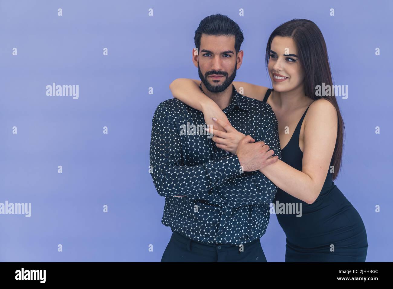 Handsome confident bearded Cuban man in a black patterned shirt being held by a long-haired beautiful caucasian girl. Supportive friends or partners. High quality photo Stock Photo