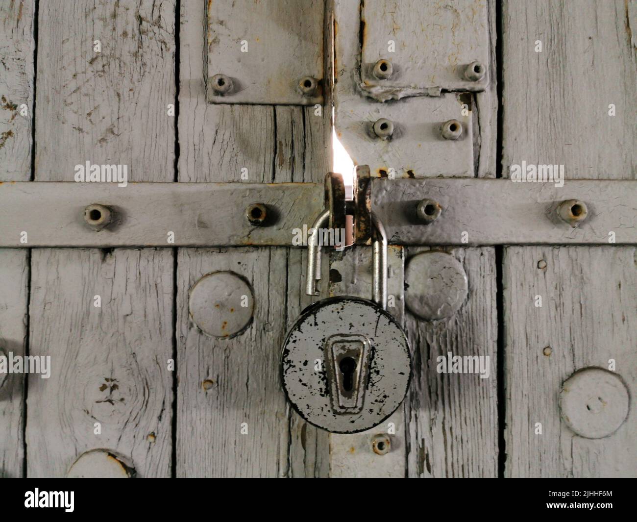 Padlock lock on wooden gates background. The padlock is open Stock