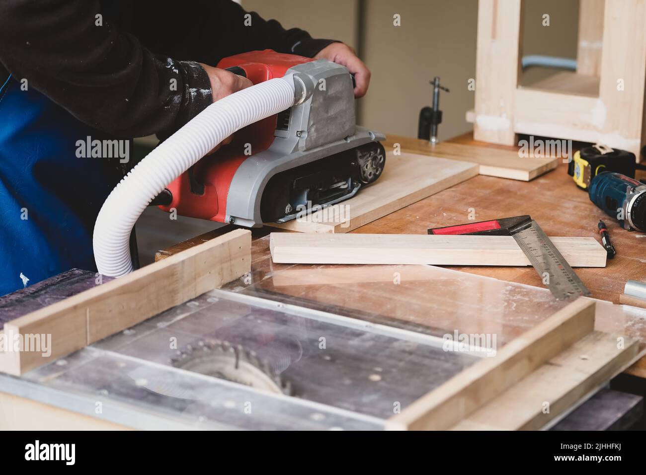 Woodworking entrepreneurs use sandpaper finishing machines to assemble and build wooden tables