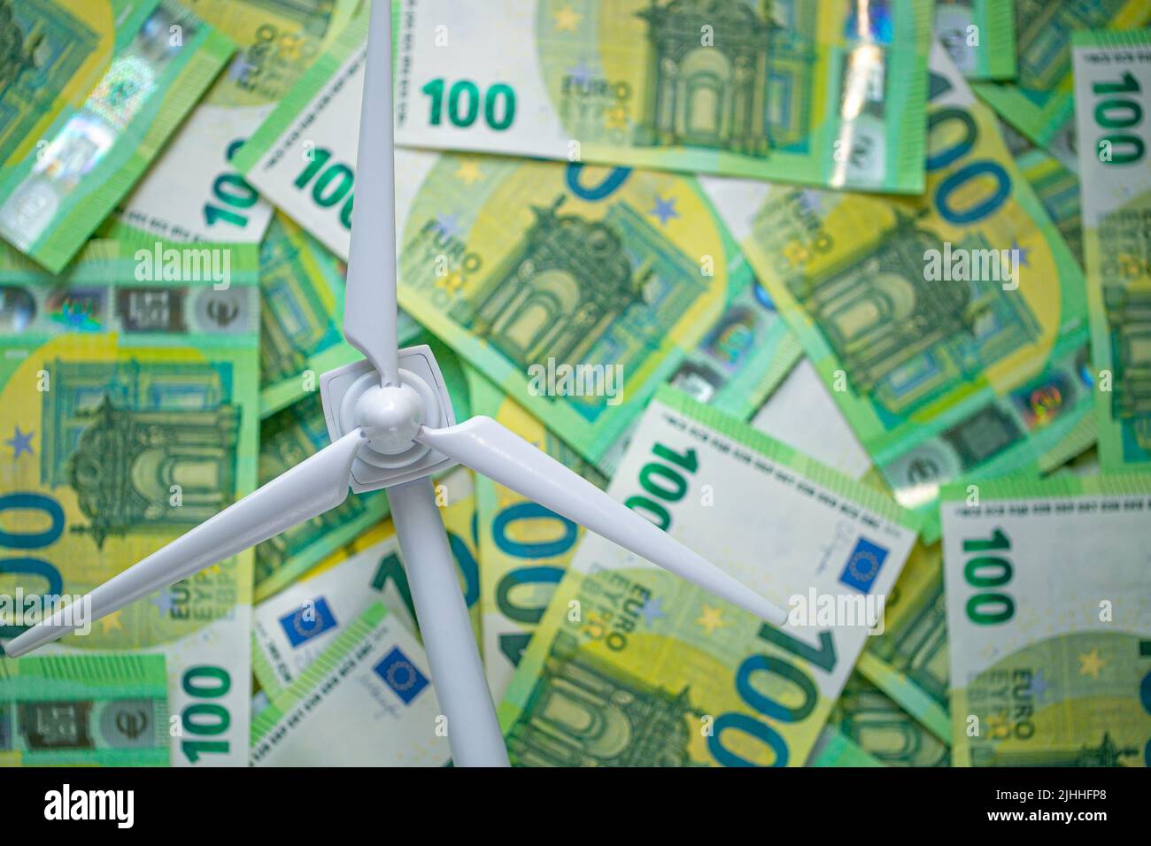 price Green energy. Payment for wind energy. cost of green renewable energy. white wind generator on green euro bills background.Alternative energy . Stock Photo