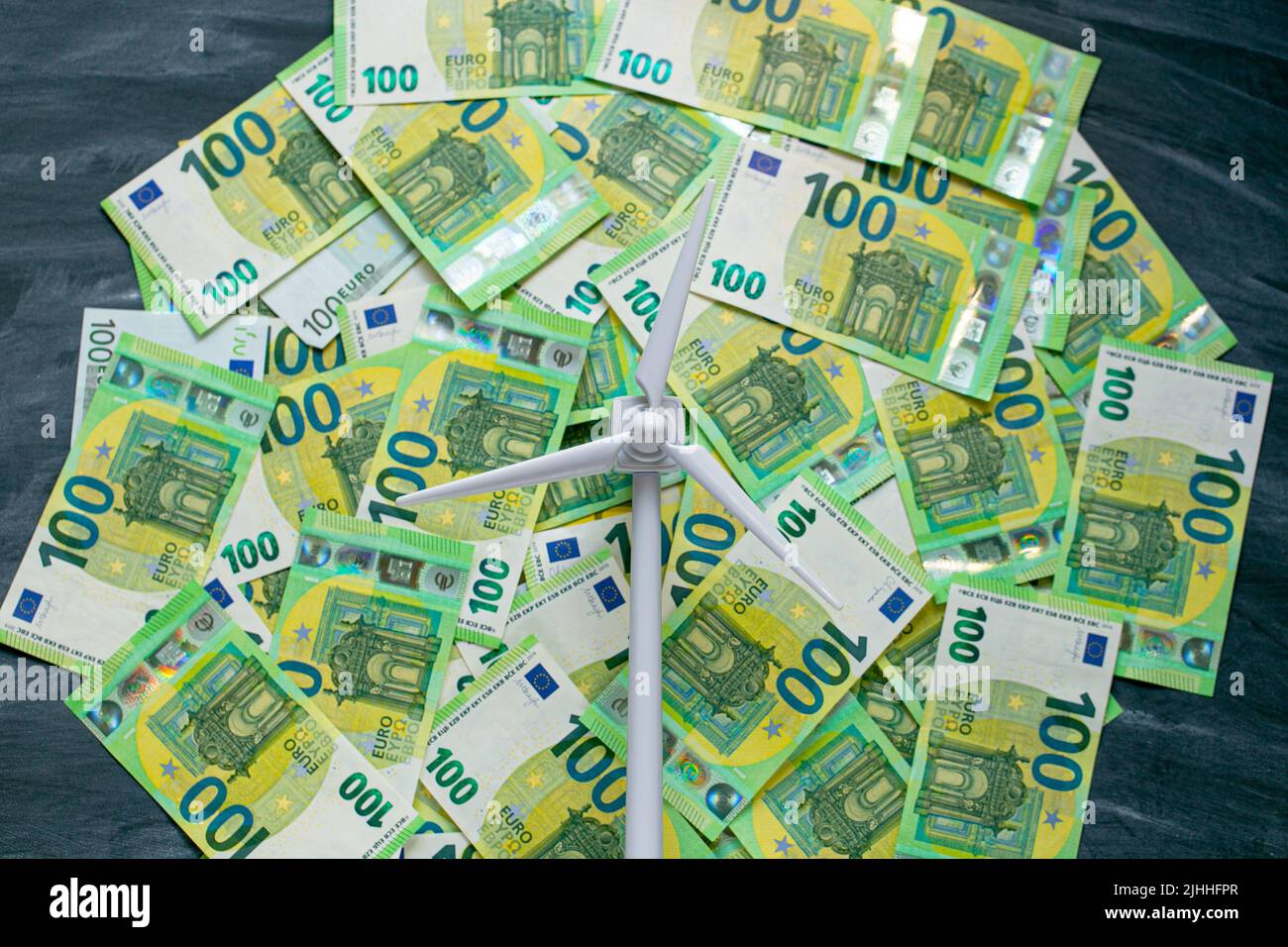Green energy cost. Payment for wind energy. cost of green renewable energy. white wind generator on green euro bills background.Alternative energy . Stock Photo
