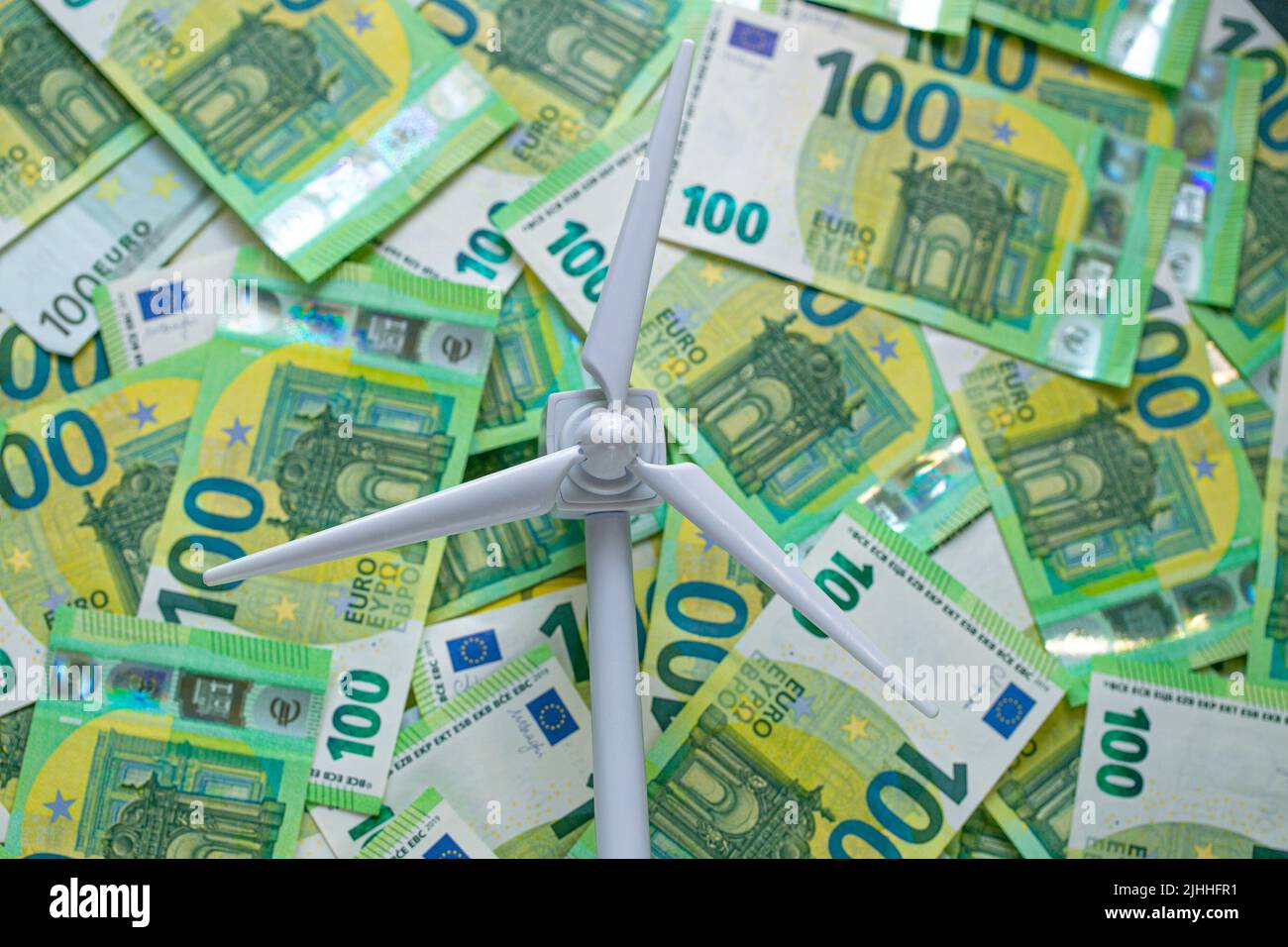 Wind energy price. Payment for wind energy. cost of green renewable energy. white wind generator on euro bills background.Alternative energy sources Stock Photo