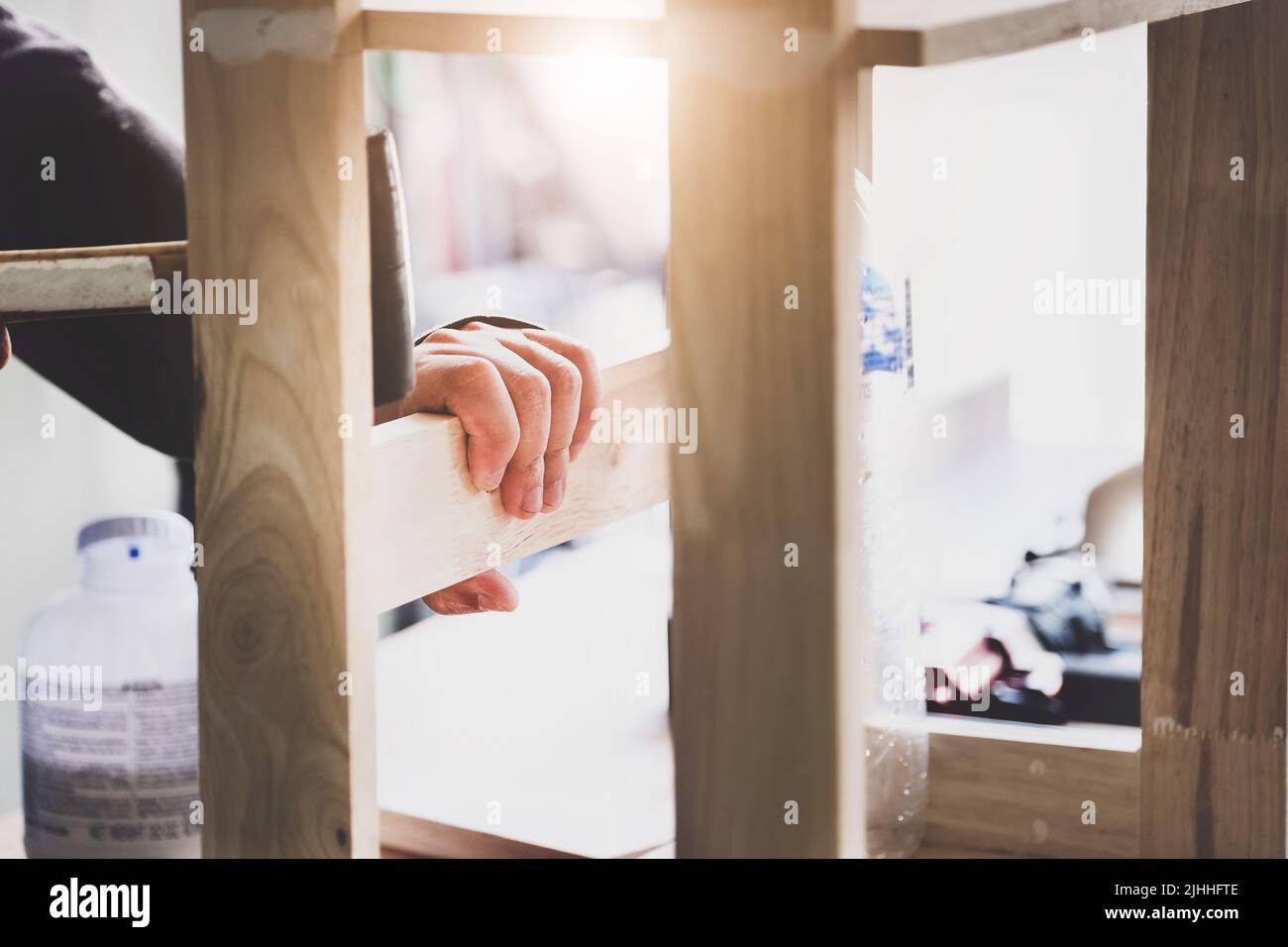 A carpenter measures the planks to assemble the parts and build a