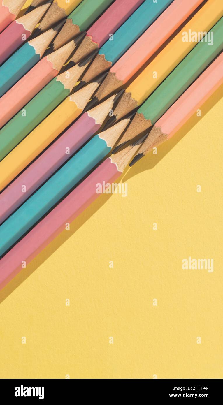 Colored wooden pencils on yellow background. Top view with copy space. Flat lay. Back to school concept. Stock Photo