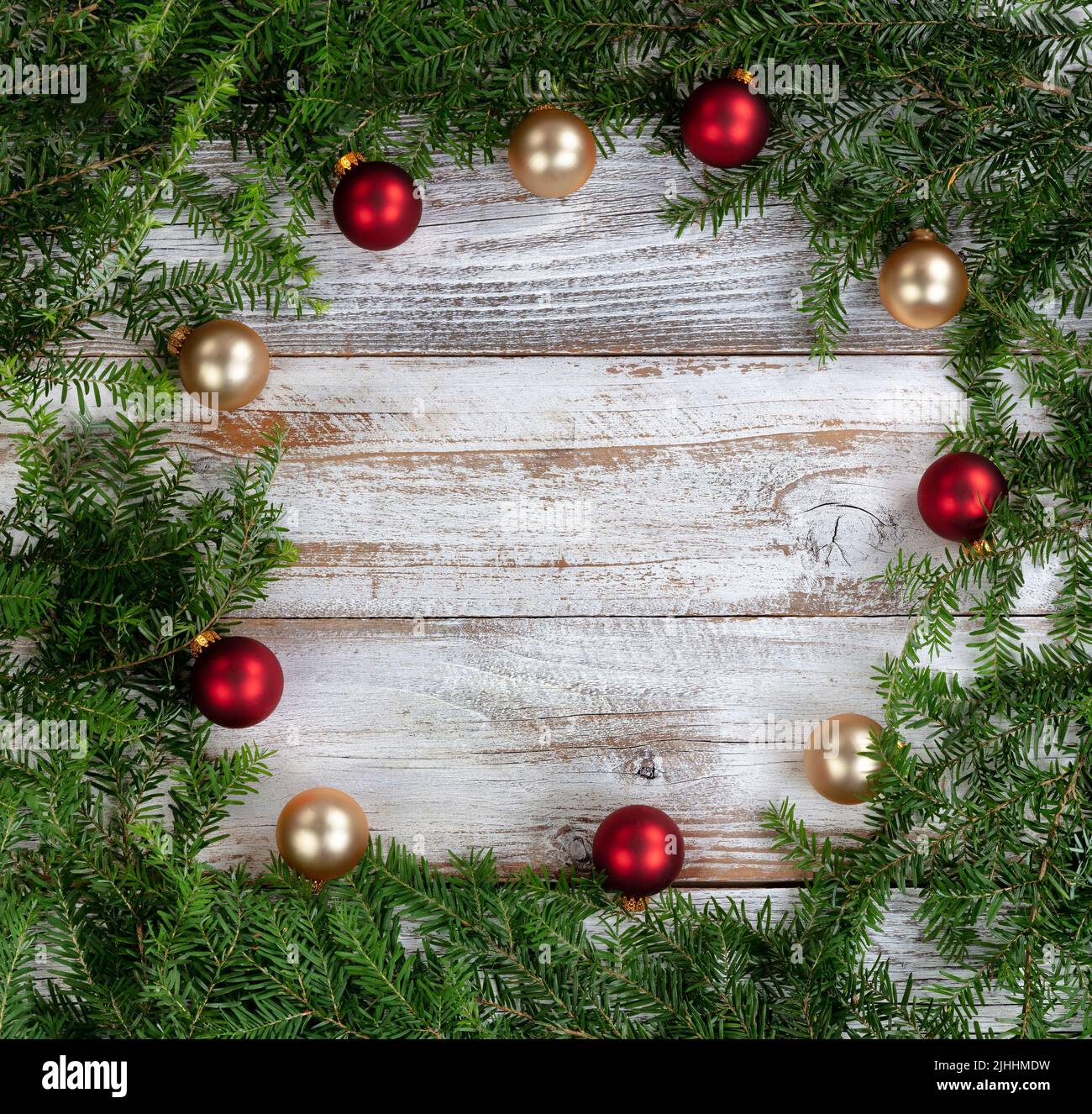 Real fir wreath with gold and red ball ornaments on white rustic wood for the Christmas or New Year holiday concept Stock Photo