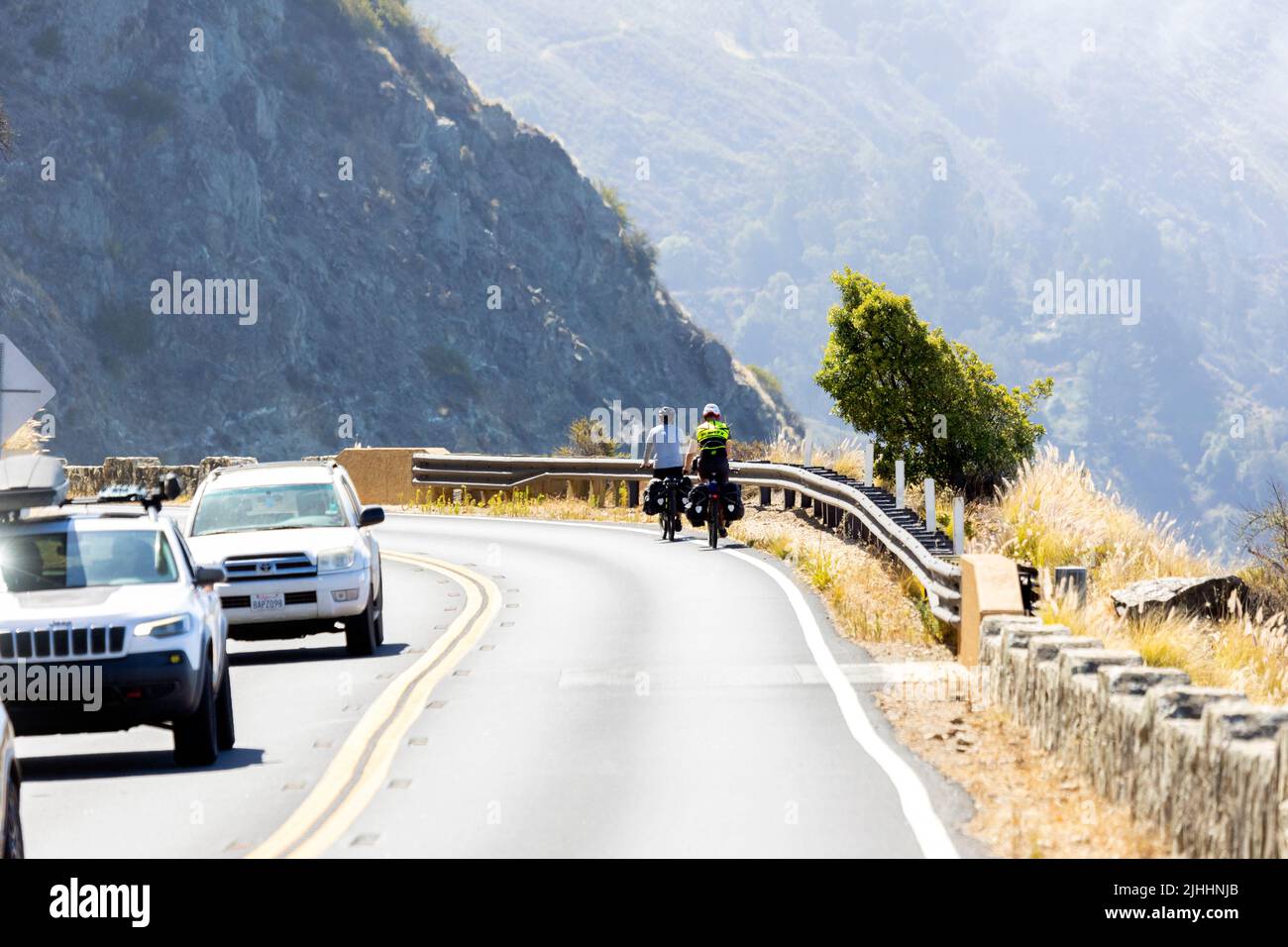 Two Bicycle Riders on Pacific Coast Highway Stock Photo