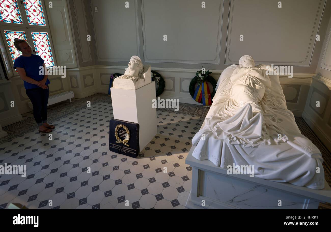 12 July 2022, Mecklenburg-Western Pomerania, Hohenzieritz: Christine Henning, Museum Education, is standing in the death chamber of Queen Luise of Prussia (1776 -1810) in the palace next to the 'Bust Segment of the Tomb Figure of Queen Luise' (c. 1820 - 1830) by Christian Daniel Rauch. On the right lies the 'Grave Figure of Queen Luise of Prussia' (plaster cast of the Neustrelitz marble copy). The original bust has now been returned to the memorial. The bust is to be presented in Hohenzieritz on 'Luise Day' (19.07.2022) on the occasion of the 212th anniversary of the death of the once beloved Stock Photo