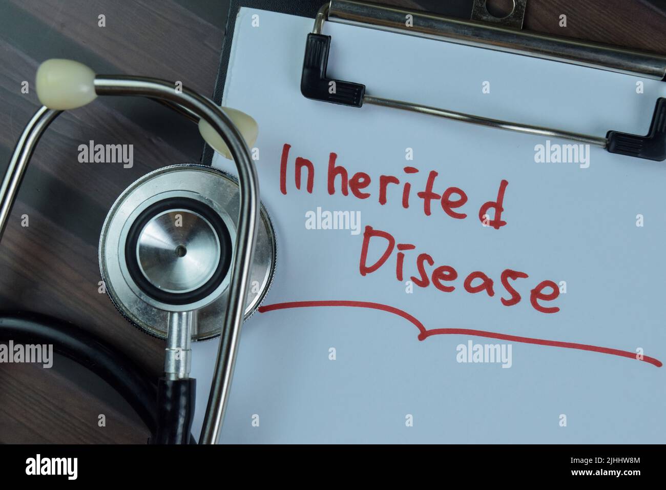 Concept of Inherited Disease write on a paperwork with stethoscope isolated on Wooden Table. Stock Photo