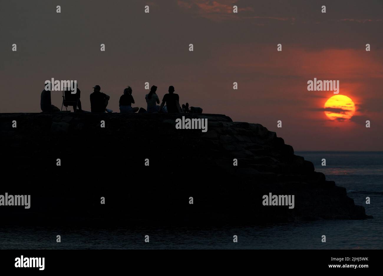 People turn out to watch the sunrise at Cullercoats Bay, North Tyneside. Britons are set to melt on the hottest UK day on record as temperatures are predicted to hit 40C. Picture date: Tuesday July 19, 2022. Stock Photo