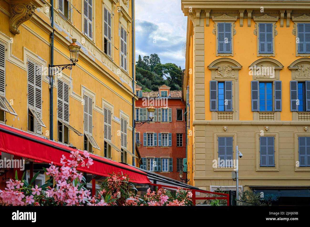 Mediterranean house facades with traditional shutters near the local outdoor farmers market Cours Saleya in the Old Town Vieille Ville, Nice, France Stock Photo