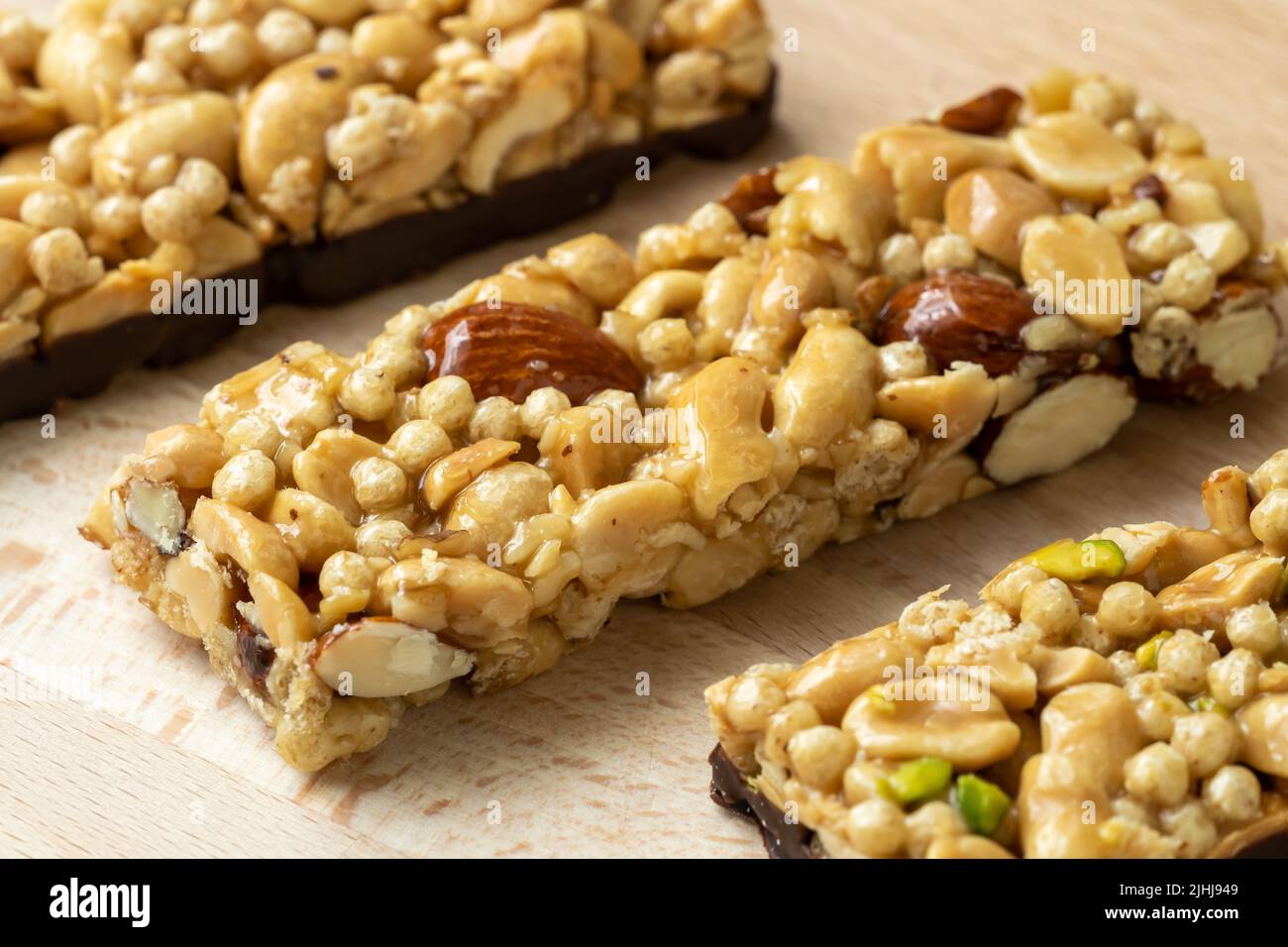 Cereal superfood energy bars with almond nuts, dry fruits, raisins chocolate on the wood table Stock Photo