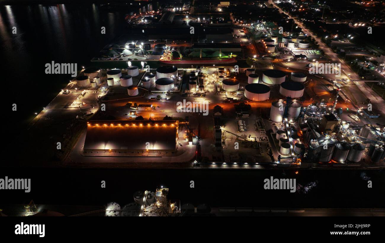 A high, aerial view looking at manufacturing facilities and industrial storage tanks while illuminated late at night. Stock Photo