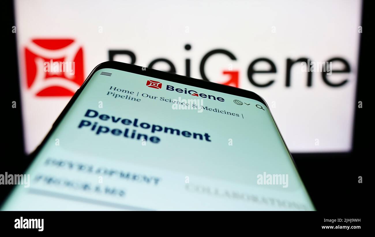 Mobile phone with website of Chinese biotechnology company Beigene Ltd. on screen in front of business logo. Focus on top-left of phone display. Stock Photo