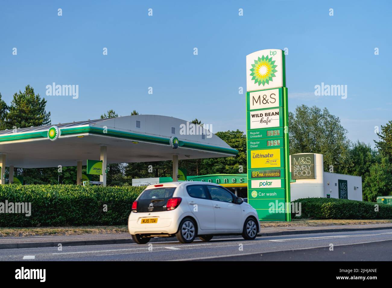 BP petrol station showing high UK fuel price sign and car in motion Stock Photo