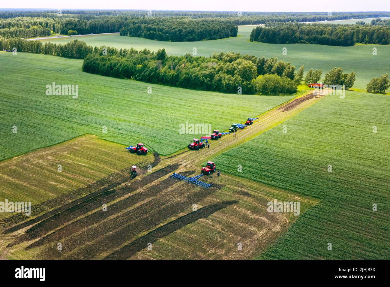 Tractor with plow on soil cultivating. tractor bowling field, drone