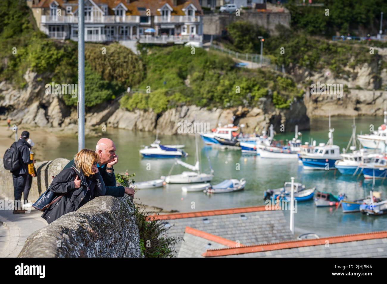 A couple of tourists enjoying the view over the historic picturesque working Newquay Harbour in Newquay on the North Cornwall coast. Stock Photo